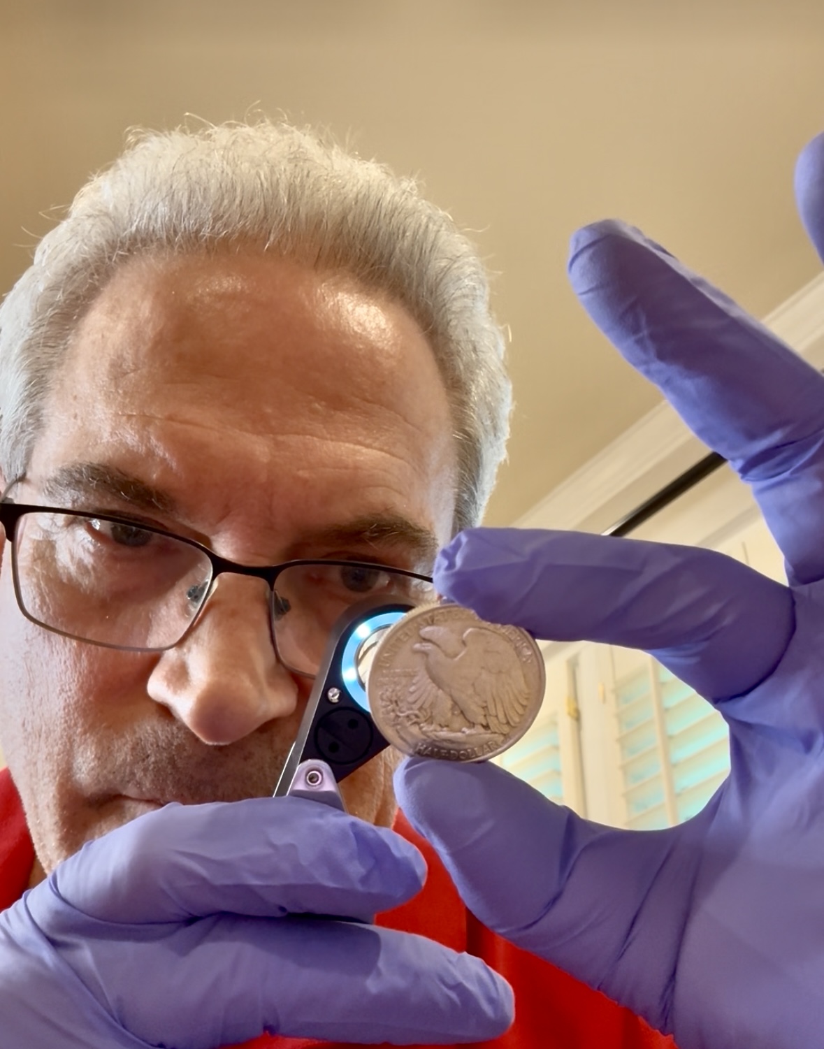 Martin Belson MD using loupe to examine coin